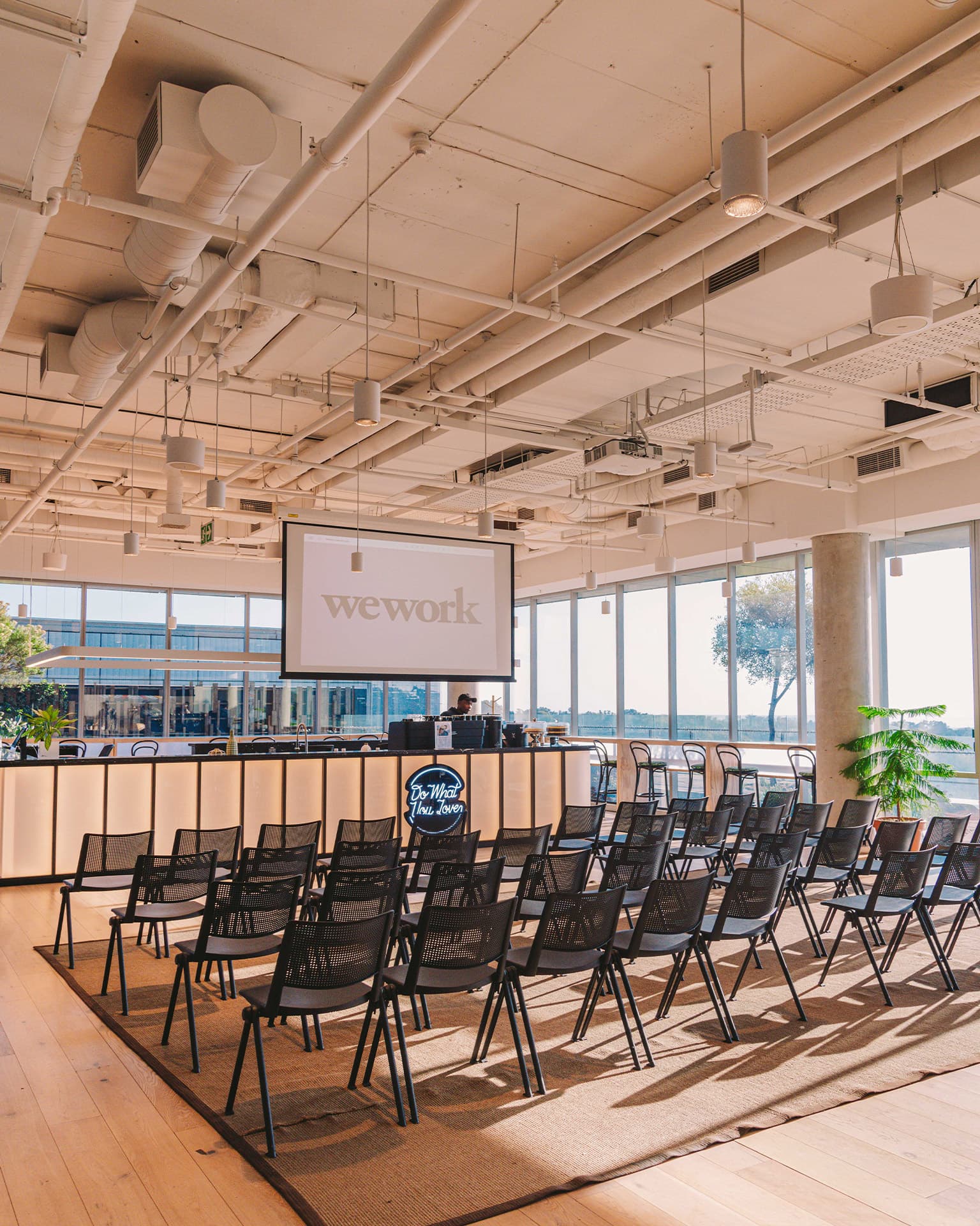 View of the event space, includes chairs and a presentation screen and the barista