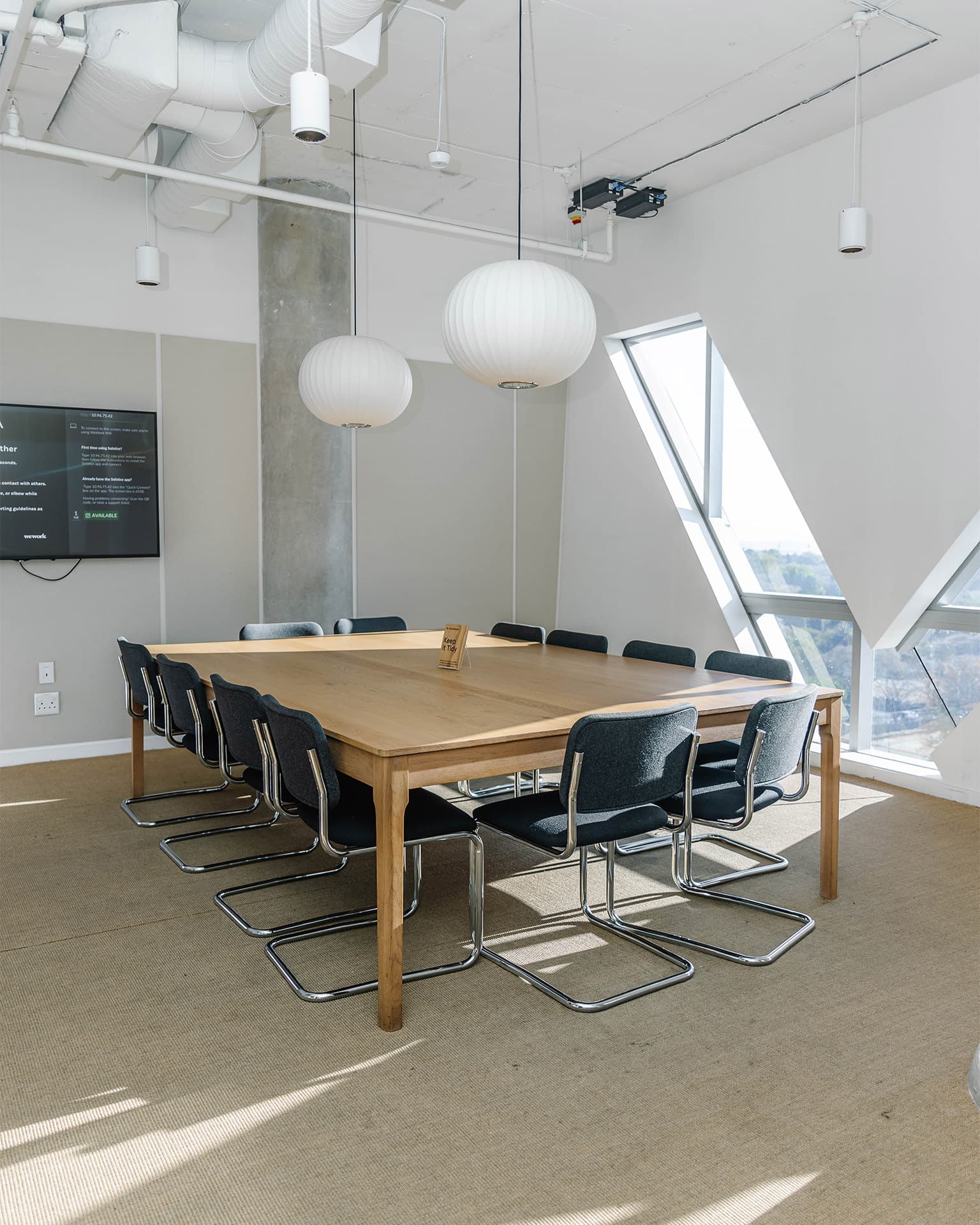 Meeting room with a bunch of chairs around a table with a TV for presentation